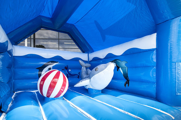 Achetez un château gonflable d'intérieur multifun bleu avec toboggan sur le thème des dauphins avec de gros objets 3D sur le dessus pour les enfants. Commandez des châteaux gonflables en ligne chez JB Gonflables France