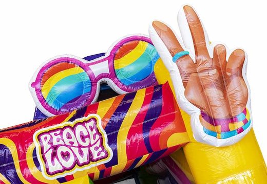 Commandez un château gonflable gonflable avec toboggan sur le thème hippie avec de nombreuses couleurs pour les enfants